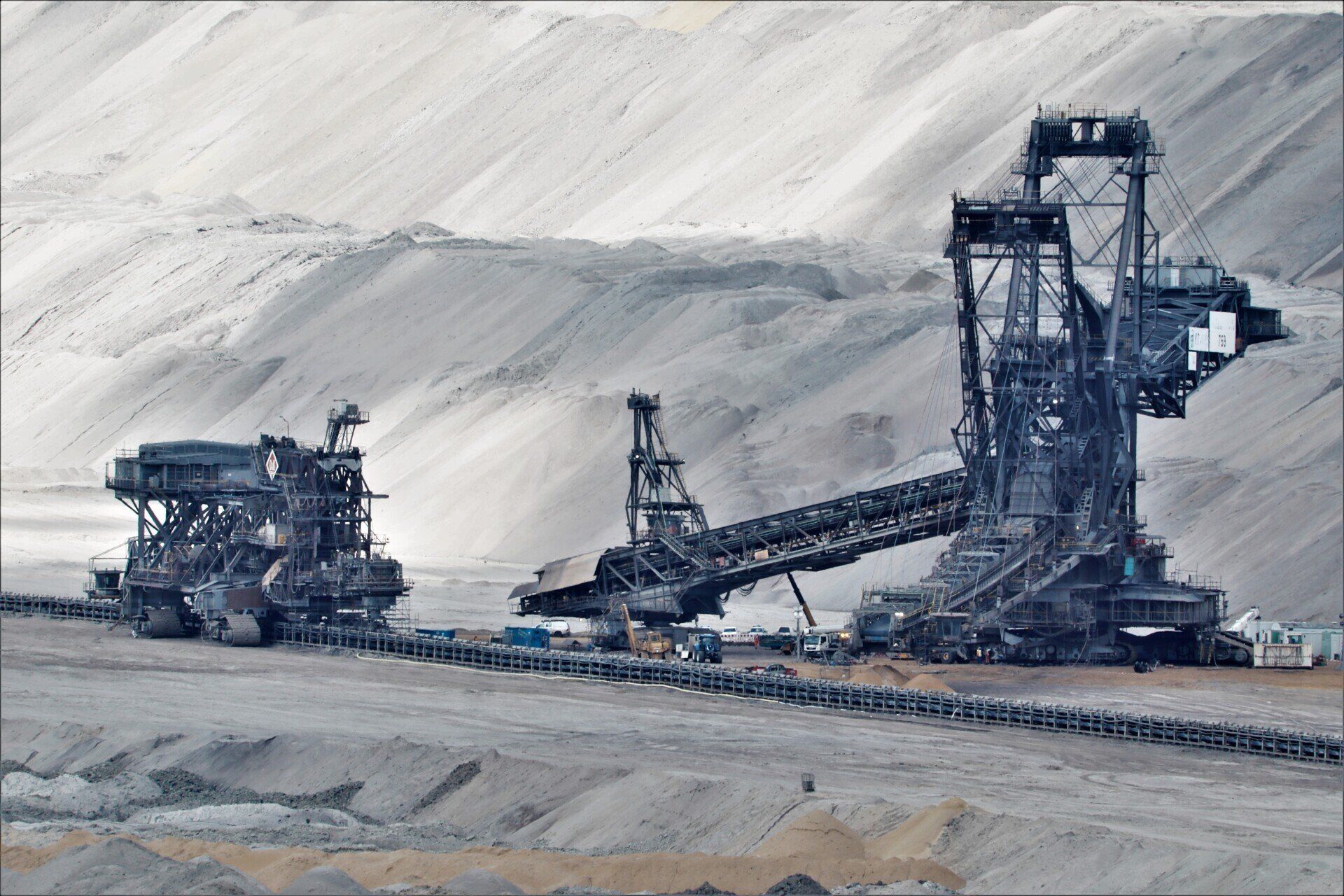 A large machine is sitting in the middle of a dirt field.